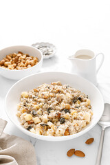 Oatmeal bowl. Oat porridge with nuts, apple, chia seeds and pumpkin seeds for healthy breakfast or lunch. Healthy vegan food, diet