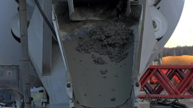 Concrete is discharging from the truck mixer at a construction site.
