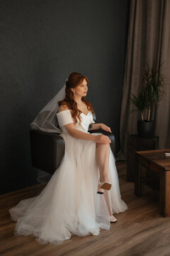 portrait of a bride girl with red hair in a white wedding dress