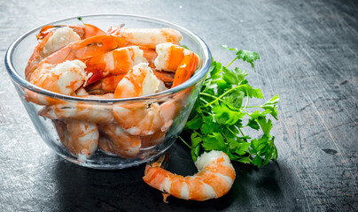 Cooked shrimps in a bowl with greens.