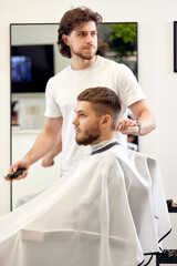 man visiting professional hairstylist in barber shop