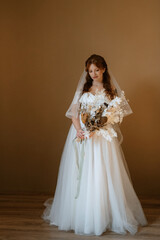 Fototapeta premium portrait of a bride girl with red hair in a white wedding dress