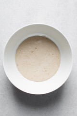 Instant dry yeast sprinkled on warm water, Activated yeast, dry yeast granules on water, foamy yeast