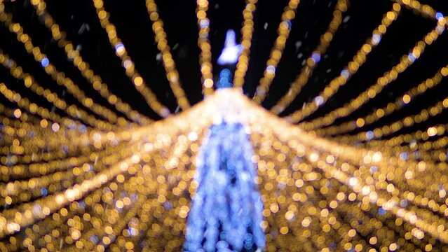 Christmas mood, snow in the background abstract bokeh New Year's decorated city tree in defocus. Christmas in the city, Christmas holidays