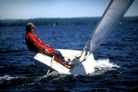 Man sailing solo on lake.