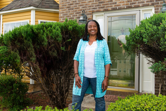 Smiling African-American Woman Standing In Front Of Her House