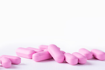 Obraz na płótnie Canvas Pink medicine pills on a white background