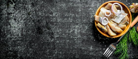 Fillet of salted herring with herbs and garlic cloves.