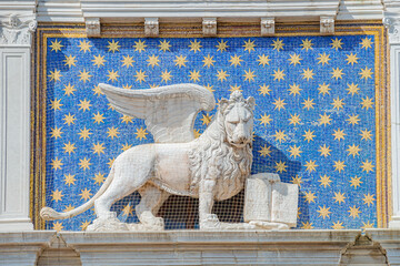 Wise winged lion with a Bible, Venetian symbol, at blue night sky with stars in Venice, Italy, at...