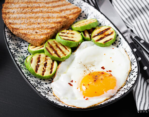 Breakfast. Toast with avocado guacamole, grilled zucchini and fried egg.  Brunch.