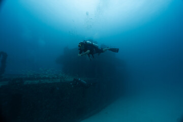 male diver posing in front of a sunken ship, technical diving