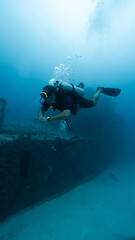 male diver posing in front of a sunken ship, technical diving