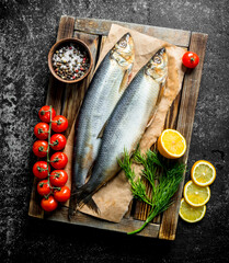 Salted herring on tray with tomatoes, lemon, dill and spices.