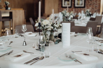 Blumen und Kerzen auf gedecktem Hochzeitstisch