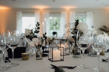 Blumen und Kerzen auf gedecktem Hochzeitstisch