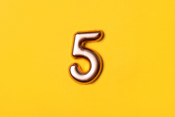 Naklejka premium Metal number five on a yellow background. Top view.