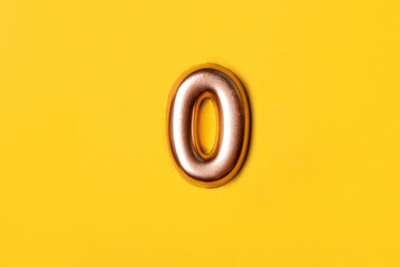 Metal number zero on a yellow background. Top view.