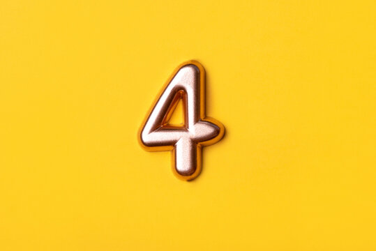 Metal number four on a yellow background. Top view. - Powered by Adobe