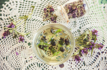 Prunella vulgaris (known as common self-heal, heal-all, woundwort, heart-of-the-earth, carpenter's herb, brownwort and blue curls herbal tea with dry and fresh herb. Vintage picture style.