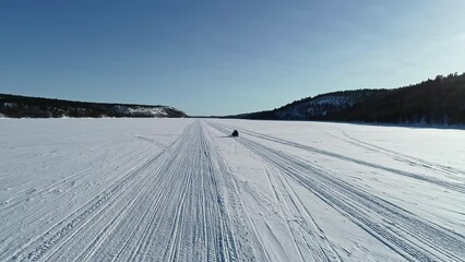 the snowy vast landscape of Norway Kirkenes during the winter season, a snowmobile on white plain snow in Norway. Aerial drone panoramic view of a white landscape. - Powered by Adobe
