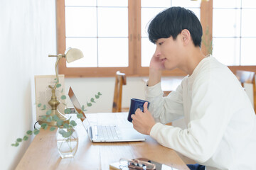 自宅でパソコンを眺める男性