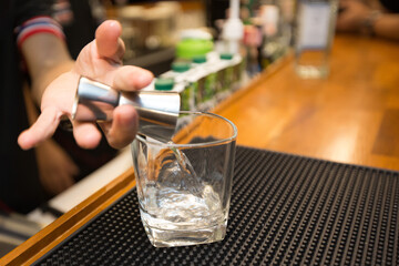 Bartender mixing cocktails for customers on bar counter