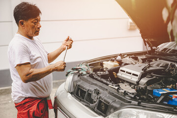 Asian male garage mechanic worker fix replace oil engine service repair broken car