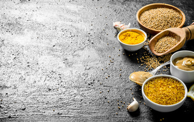 Different types of mustard with garlic cloves.