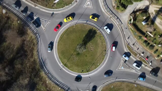 Aerial view of driving exclusive sports cars in urban roundabout, luxury colourful cars performing on the streets in traffic time, sports cars on road junctions 