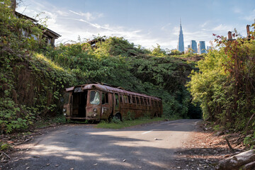Ruins overgrown by plants. In foreground a old rusted bus. In a city skyline. Generative AI