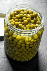 Canned green peas in a glass jar.