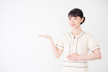 手で案内するエステ・美容クリニックの女性