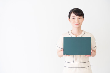 Fototapeta premium 黒板を持つエステ・美容クリニックの女性