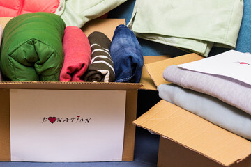 Clothes Donation. Box of warm cloth with donate label. Gathering items to be donated to charity