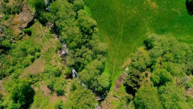 Beautiful Birdseye view of lush and green area around a freshwater fiver on a sunny summer day