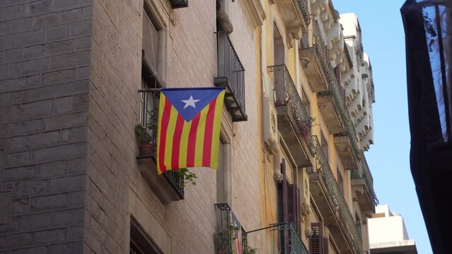 Catalonian Flag (Estelada) Billowing in a Light Wind in a Narrow Street of the Old City of Barcelona (4K)