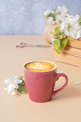 Cup of coffee and blossom apple twigs with vinage books. Springtime still life composition