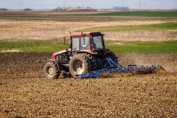 Fototapeta premium The heartbeat of the farm, tractor preparing the fields for a new cycle of life