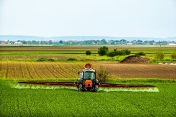 Scientific crop protection with tractor-applied herbicides, pesticides, and fungicides, farmer ensuring plant health and yield
