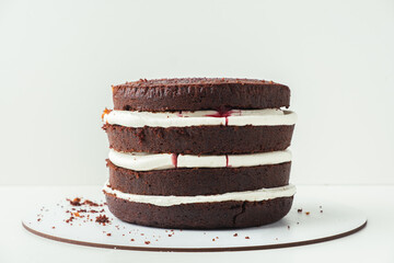 Fresh sliced sponge chocolate cake biscuit layers filled with whipped cream cheese. Cherry cake assembly process. Cake recipe background.