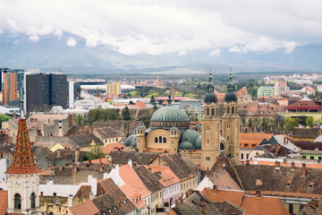 Fototapeta na wymiar Aerial cityscape of historic Sibiu city in Transilvania, Romania, and cloudy Carpathian mountains 