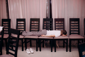 teenager sleeping on chairs during a party, laziness, apathy, bad behavior, boredom, childhood problems, fatigue