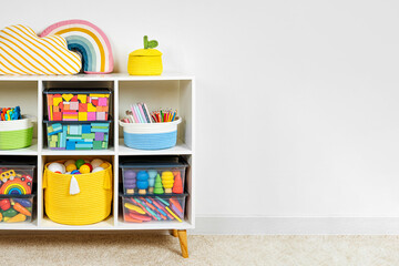 White shelving with rainbow wooden toys and colorful storage baskets and boxs. Interior design....