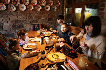 Fototapeta na wymiar Family having a meal together in authentic ukrainian restaurant.