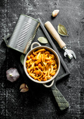 Canned honey agaric on a cutting Board with garlic and Bay leaf.