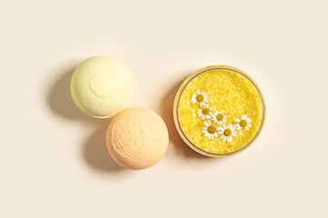 Bath salt sea and bath bomb with herbal extract of chamomile, sea salt crystals in jar, neutral beige spa background. Close up body care cosmetics, natural organic product, herbal medicine