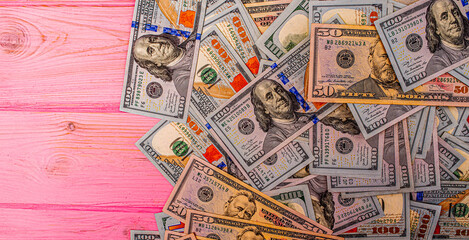 American currency on a pink wooden background. Banks and finance. Dollar paper banknotes.