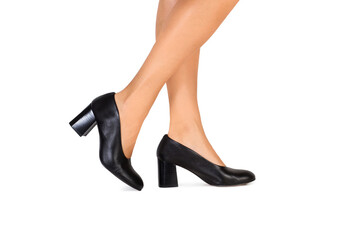 Piernas de mujer con zapatos negros sobre un fondo blanco liso y aislado. Vista de frente y de cerca. Copy space