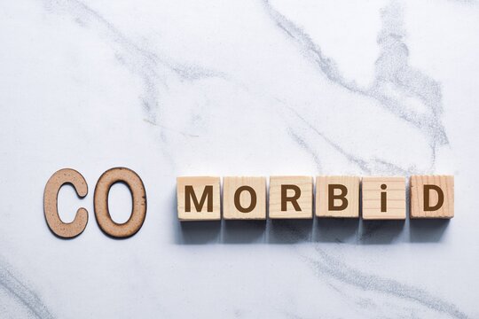 The word COMORBID in wooden letters and blocks on white background. Complex medical condition concept.