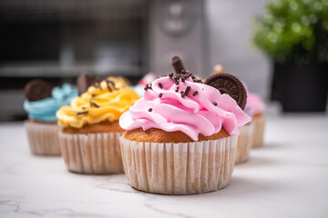 Delicious homemade cupcakes with Colorful cream and topping with candy and Chocolate Cookies. Homemade autumn holiday dessert